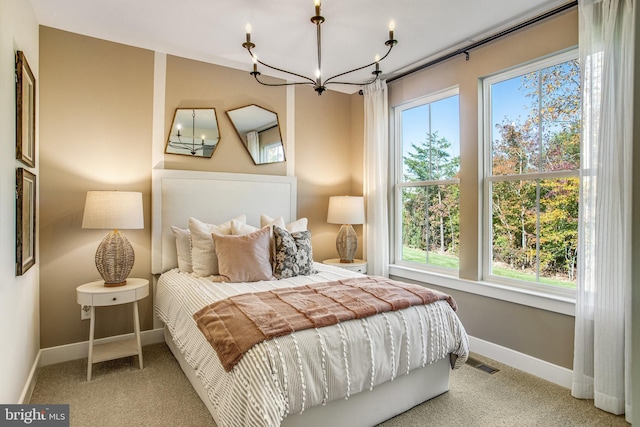 carpeted bedroom featuring an inviting chandelier