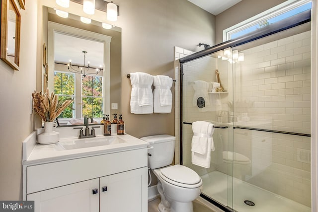 bathroom featuring vanity, a notable chandelier, toilet, and walk in shower