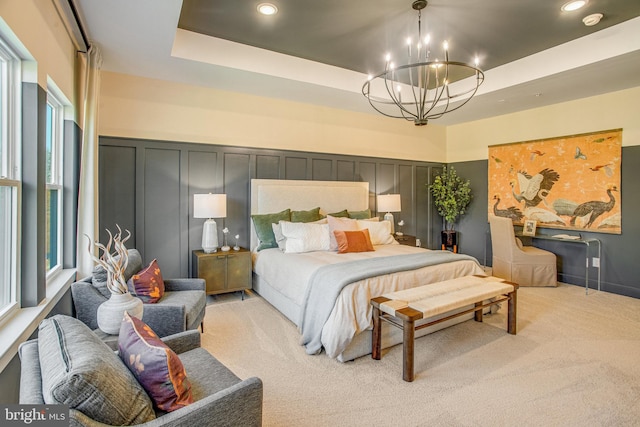 bedroom featuring light carpet, a chandelier, and a raised ceiling