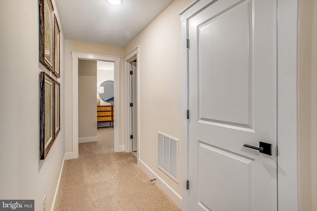 hallway featuring light colored carpet