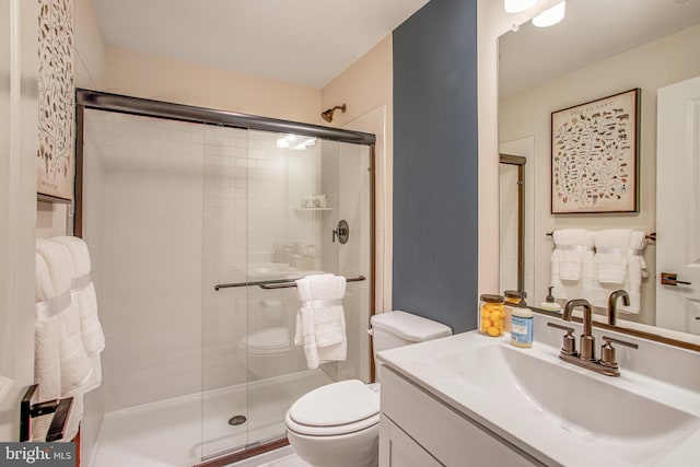 bathroom featuring vanity, toilet, and an enclosed shower