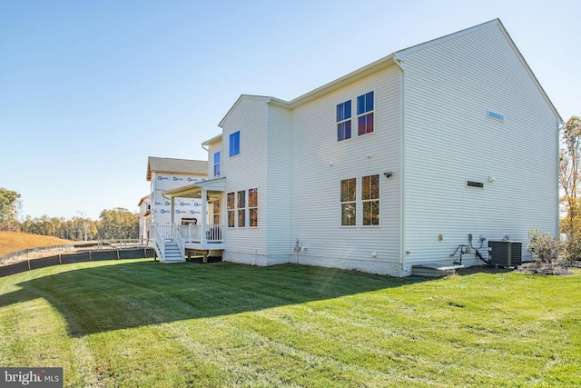 back of house featuring a yard and cooling unit