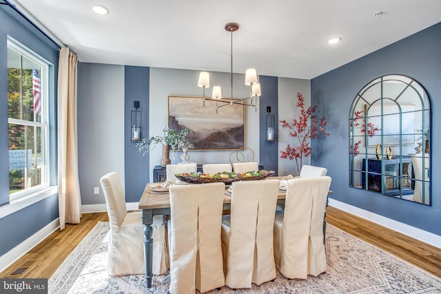 dining space featuring light hardwood / wood-style flooring and a chandelier