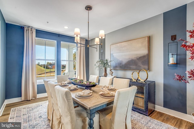 dining area with a notable chandelier and hardwood / wood-style floors