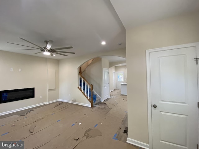 unfurnished living room with light wood-type flooring and ceiling fan