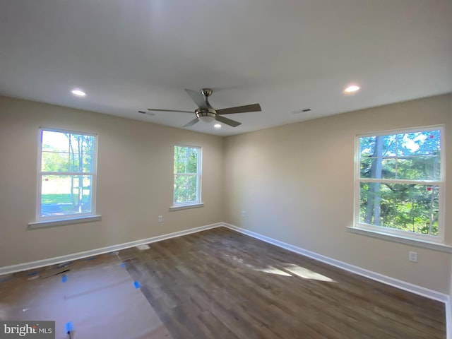 empty room with ceiling fan and dark wood-type flooring