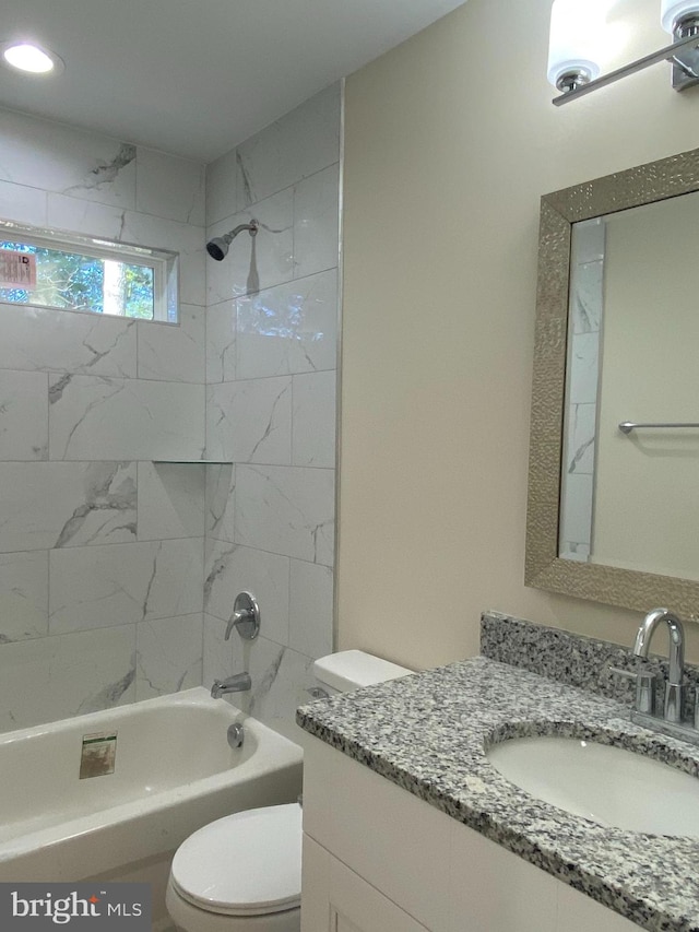 full bathroom with vanity, toilet, and tiled shower / bath combo