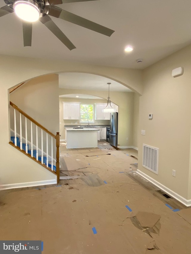 unfurnished living room with ceiling fan and sink