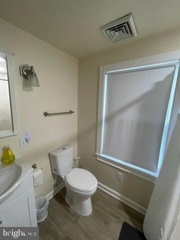 bathroom with vanity, toilet, and hardwood / wood-style floors