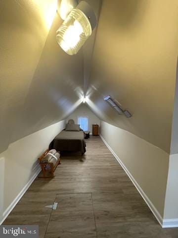 unfurnished bedroom with lofted ceiling and wood-type flooring