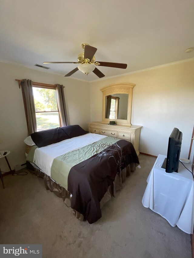 bedroom with ceiling fan, carpet flooring, and ornamental molding