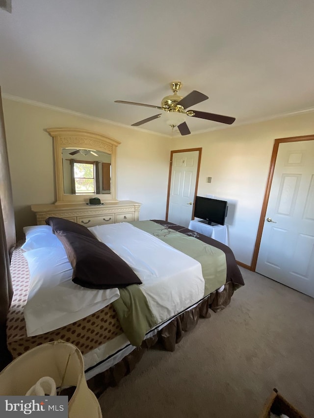 carpeted bedroom featuring crown molding and ceiling fan