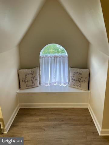 sitting room with hardwood / wood-style flooring and vaulted ceiling