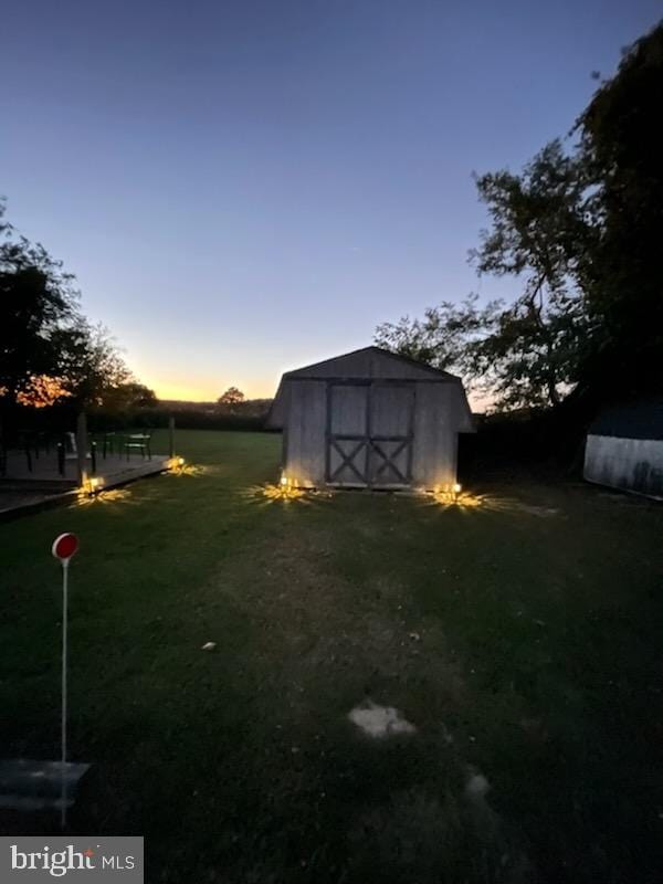 yard at dusk featuring a shed