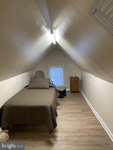 bedroom featuring vaulted ceiling and light hardwood / wood-style flooring