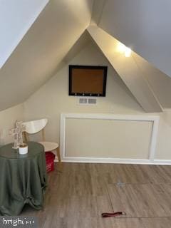 bonus room with vaulted ceiling and hardwood / wood-style flooring