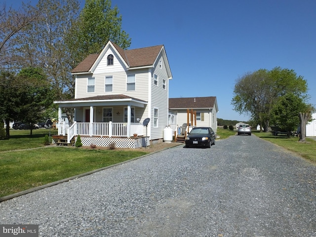 2826 Hoopers Island Rd, Church Creek, MD 21622 - traditional home featuring covered porch, gravel driveway, a shingled roof, and a front yard