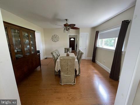 dining space with wood-type flooring and ceiling fan