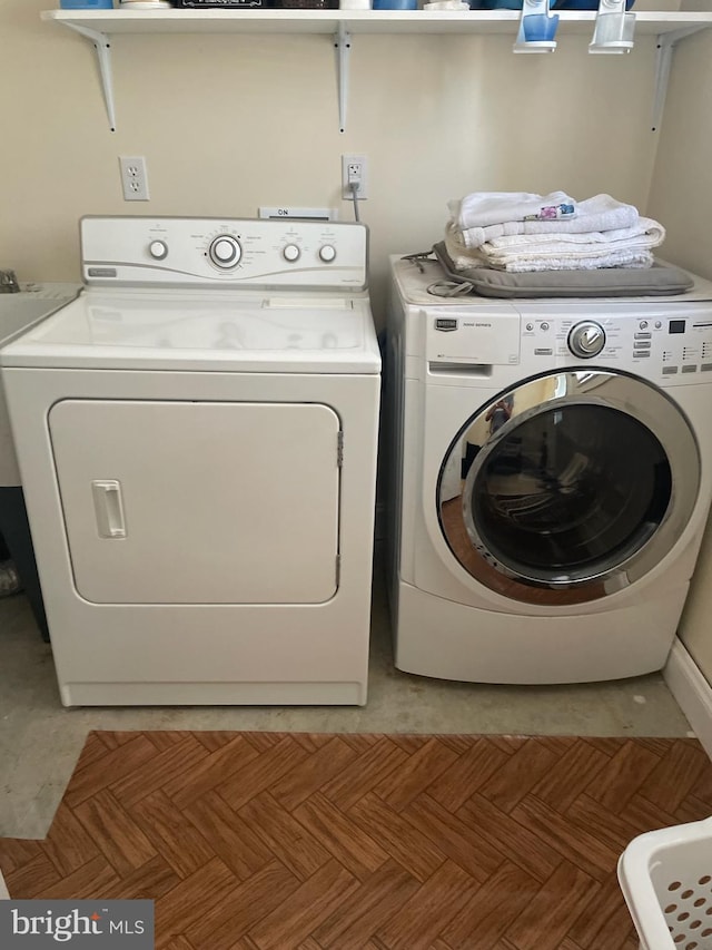 laundry room with light parquet floors and separate washer and dryer