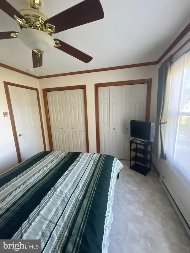 unfurnished bedroom featuring ceiling fan, ornamental molding, a baseboard heating unit, and two closets