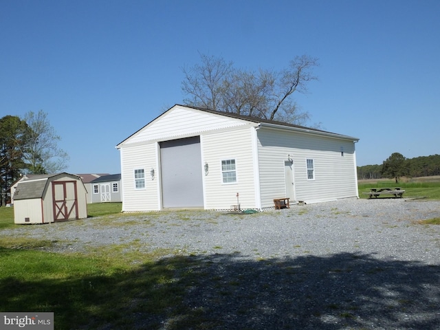 rear view of house featuring a storage unit and a yard