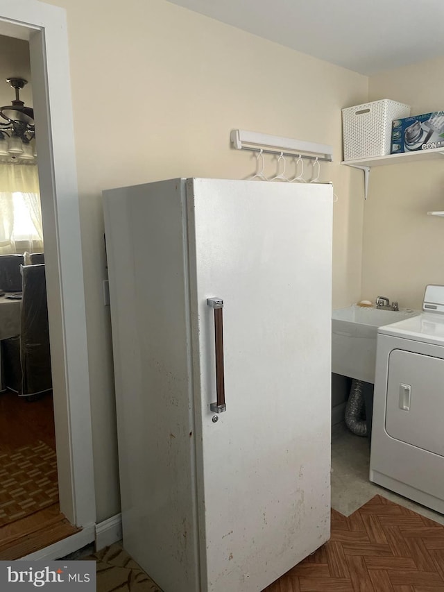 clothes washing area with washer / dryer and parquet flooring