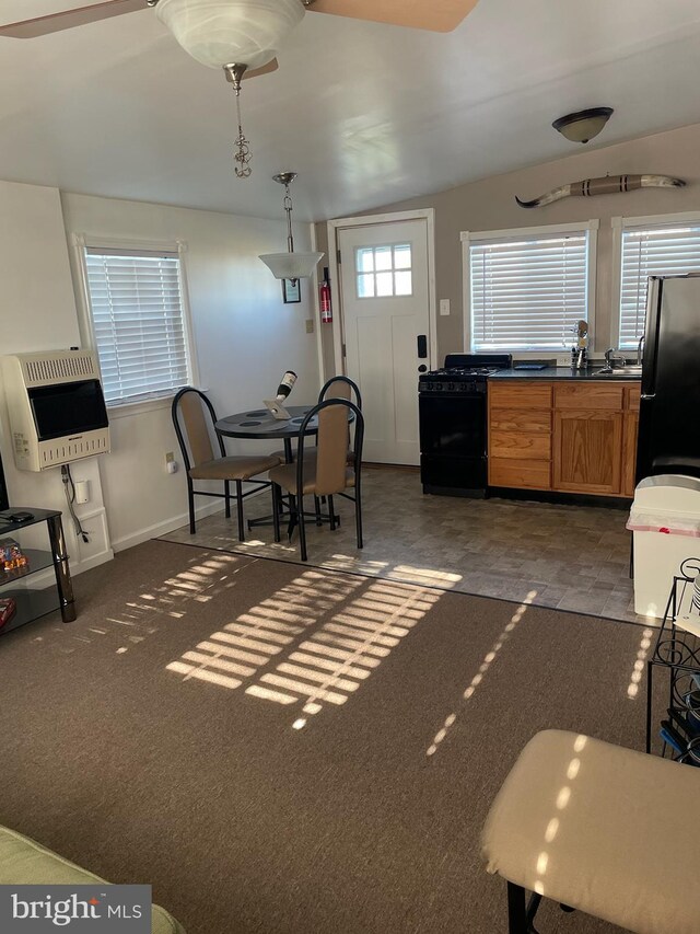 interior space featuring dishwasher, dark carpet, pendant lighting, heating unit, and stainless steel refrigerator