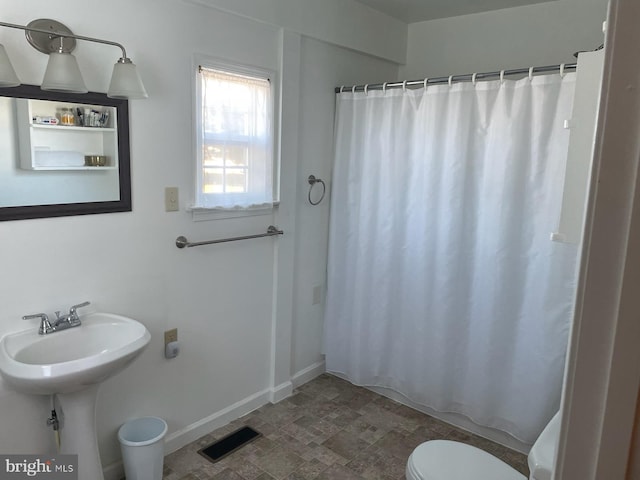 2826 Hoopers Island Rd, Church Creek, MD 21622 - bathroom with stone finish floor, curtained shower, visible vents, baseboards, and toilet