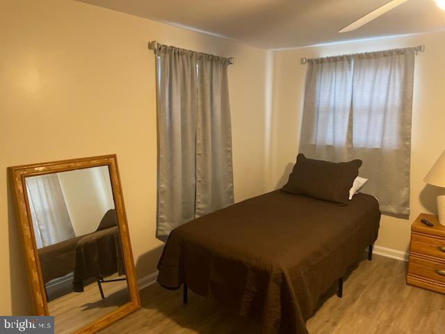 bedroom with light hardwood / wood-style floors and ceiling fan