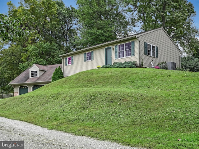 view of front facade with a front lawn and central AC