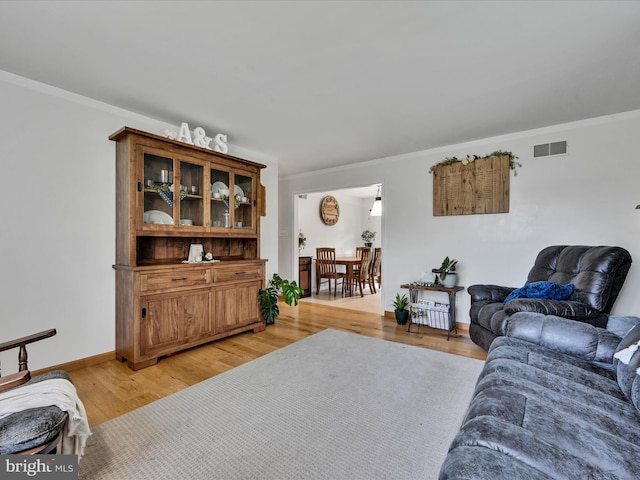 living room with crown molding and light hardwood / wood-style floors