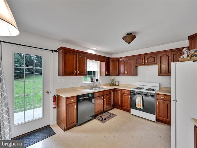 kitchen featuring black dishwasher, white refrigerator, gas range, and sink