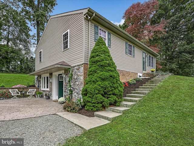 view of side of property featuring a yard and a patio area