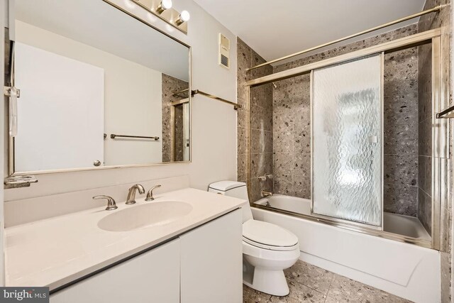 full bathroom featuring enclosed tub / shower combo, tile patterned floors, vanity, and toilet