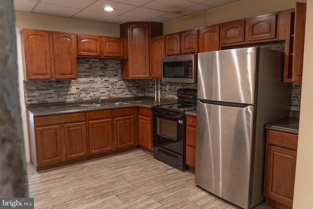 kitchen featuring sink, a drop ceiling, decorative backsplash, and stainless steel appliances