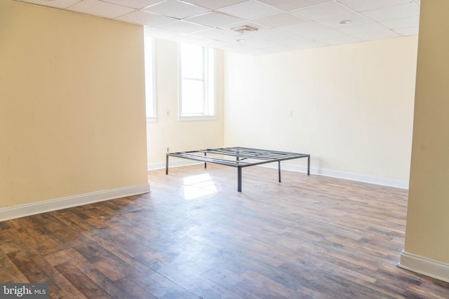 playroom featuring a paneled ceiling and dark wood-type flooring