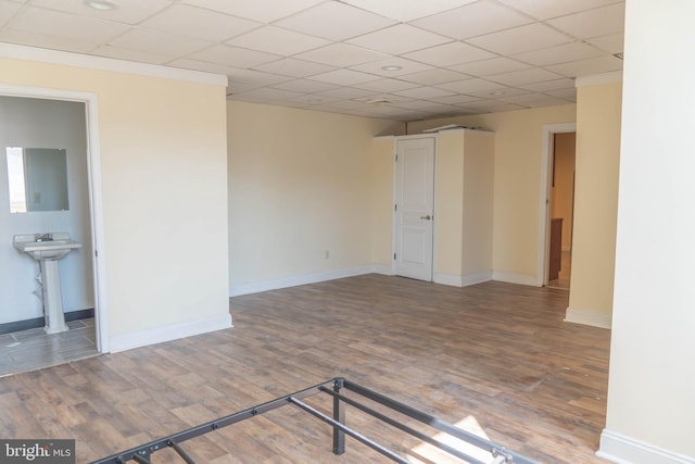 spare room with sink, hardwood / wood-style floors, and a drop ceiling