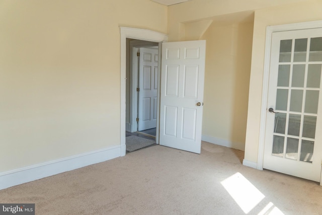 unfurnished room featuring light colored carpet