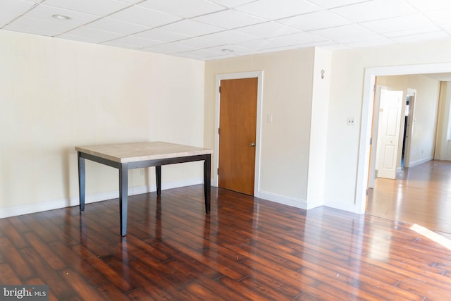 unfurnished room with a drop ceiling and dark hardwood / wood-style floors