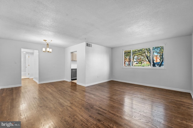 unfurnished living room featuring dark hardwood / wood-style flooring, a textured ceiling, and a notable chandelier