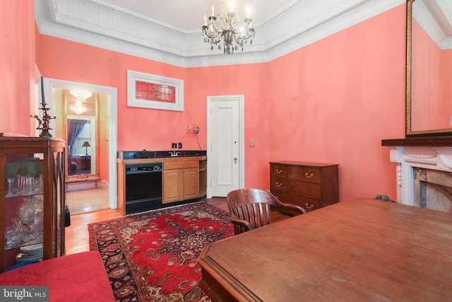 dining room featuring ornamental molding, hardwood / wood-style flooring, an inviting chandelier, and a raised ceiling