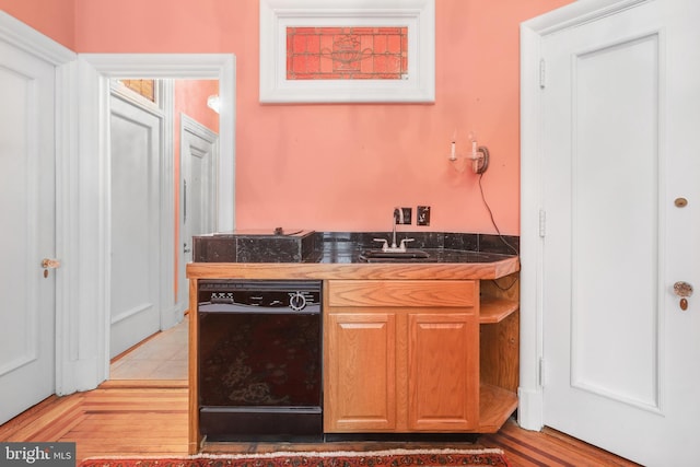 kitchen with dishwasher, light hardwood / wood-style flooring, and sink