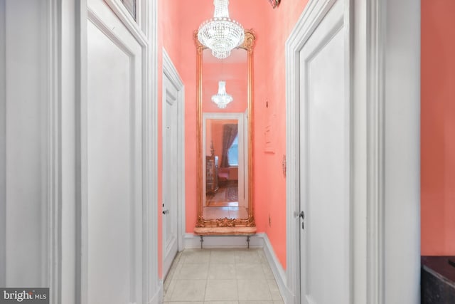 corridor featuring a notable chandelier and light tile patterned floors