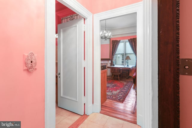 hall with an inviting chandelier and light hardwood / wood-style floors