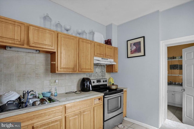 kitchen with decorative backsplash, light brown cabinets, sink, stainless steel range with electric cooktop, and light tile patterned floors