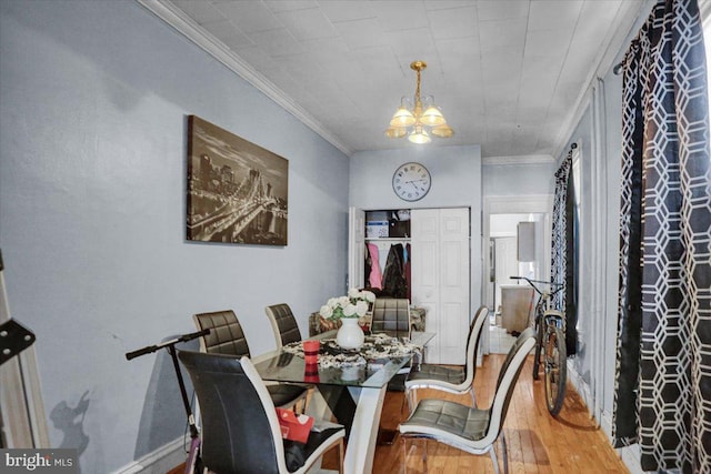 dining area with a chandelier, crown molding, and hardwood / wood-style flooring