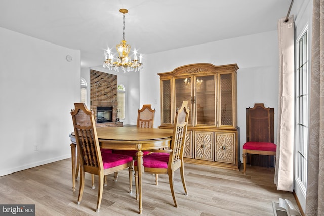 dining space with hardwood / wood-style flooring, a chandelier, and a fireplace