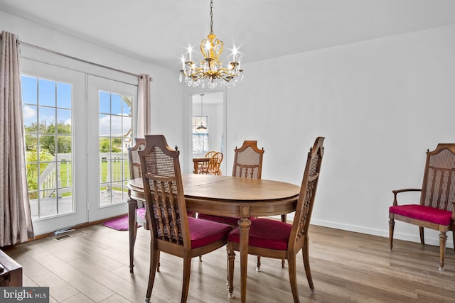 dining room with a notable chandelier, light wood-type flooring, and a wealth of natural light