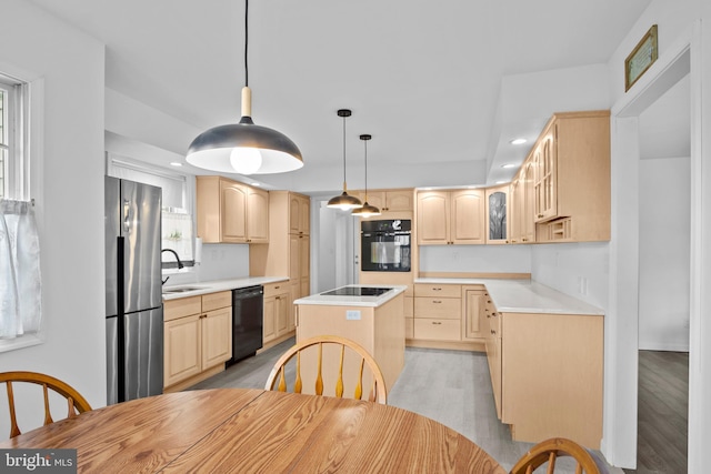 kitchen with a kitchen island, light brown cabinets, light hardwood / wood-style floors, and black appliances