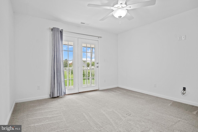 carpeted spare room with ceiling fan